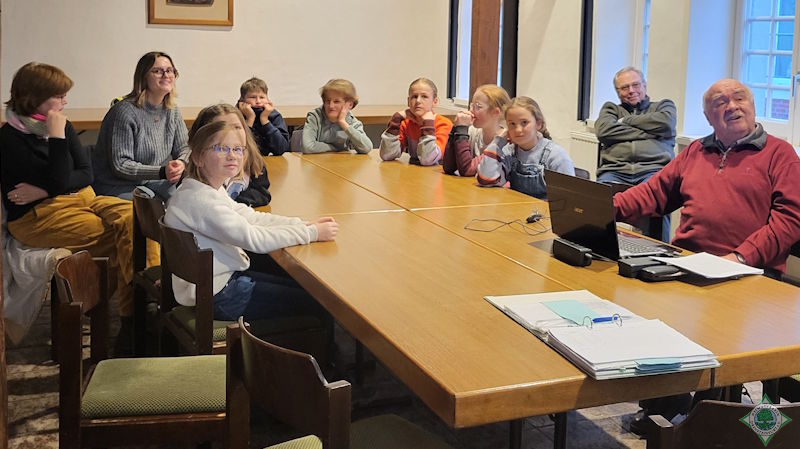Das Bild zeigt die Gruppe während der Diaschau mit historischen Fahrzeugen
