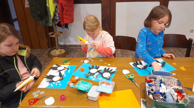 Kinder basteln Pinguine.